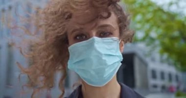 Genç ve güzel bir bankanın portresi, tıbbi maske takan bir saray çalışanı. Kendine güvenen beyaz bir iş kadını kameraya bakıyor ve antiseptik püskürtüyor. Dezenfeksiyon, sağlık önlemleri.