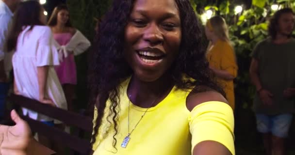 Punto de vista de alegre chica afroamericana hablando de buen humor. Hermosas chicas asiáticas y caucásicas agitando sus manos. Guapos hombres felices sonriendo. Jóvenes de razas mixtas en la fiesta del jardín. Concepto de conversación — Vídeos de Stock