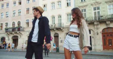 Kasabanın sokaklarında dans eden neşeli genç bir çift. Keyifleri yerinde. Beyaz, şapkalı, neşeli, yakışıklı bir adam ve güzel bir kız kalabalık bir şehirde komik hareketler yapıyor ve gülümsüyor. Komik dans. Eğlenceli konsept