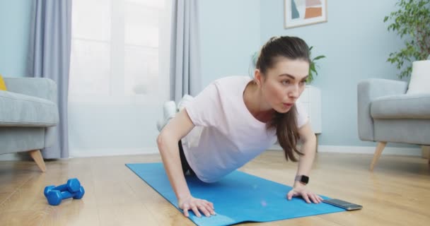 Middle plan of tone up woman doing fitness workout and press ups exercisions for healthy lifestyle and strong hands in living room στο σπίτι. Υγιής και αθλητικός τρόπος ζωής. Εκπαίδευση, προπόνηση και ευεξία. — Αρχείο Βίντεο