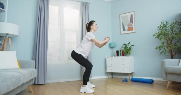 Plan latéral moyen d'une belle femme brune faisant de l'exercice de remise en forme et des exercices assis pour un mode de vie sain et des abdominaux forts à la maison. Sport et fitness. Concept de formation, entraînement et bien-être. — Video