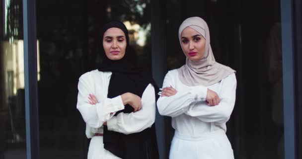 中图,年轻的穆斯林美女,身穿传统头巾,交叉着胳膊,看着相机.在街上用漂亮的眼睛围观阿拉伯女性. — 图库视频影像