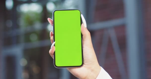 Caddedeki kadınların elindeki yeşil ekran akıllı telefonun yakın plan görüntüsü. Yeşil Model Ekran Kroması ile Telefon Kullanan Kadın İçerik Videoları İzleme Blog 'u — Stok video