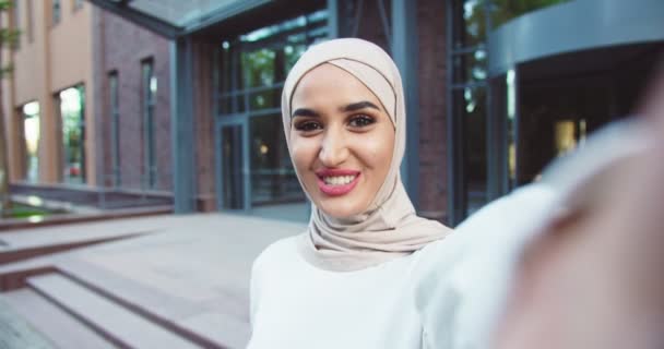屋外に立っている伝統的なスカーフで若いイスラム教徒の美しい女性のハメ撮りとウェブカメラを介して話しています。ビデオチャットの概念。可愛いです女性ともに手で手を振ってカメラとビデオ撮影. ストック動画 © ihorvsn@gmail.com #411430774
