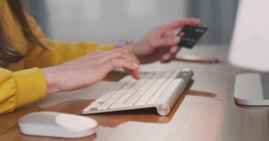 Kafkas kadınlarının klavyeye yazı yazarken ve masa başında otururken bilgisayar faresi kullanırken yakın plan çekimleri. Kadın, internet üzerinden kredi kartıyla ödeme yaparken parmaklarını tıklatıyor.