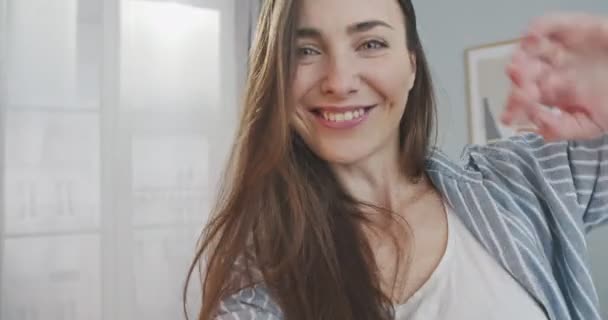 POV de hermosa chica feliz caucásica sonriendo y hablando en videollamada en la sala de estar en casa. Primer plano retrato de alegre bonita mujer teniendo video chat en el interior de buen humor. Concepto de conversación — Vídeos de Stock