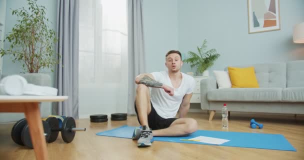 Jonge sportieve blogger met online training praten met kijkers. Aantrekkelijke vent die thuis traint tijdens quarantaine, isolatieperiode, afsluiting. Sportconcept: fit blijven, gewichtsverlies. — Stockvideo