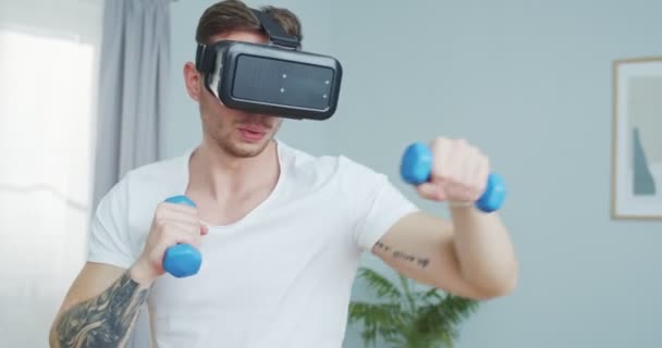 Retrato boxeador caucasiano em vr óculos de treinamento, divertido em casa. Atraente forte ajuste boxe masculino, lutando segurando pesos. Jogos de realidade virtual. Desporto digital, conceito de ciberespaço. — Vídeo de Stock