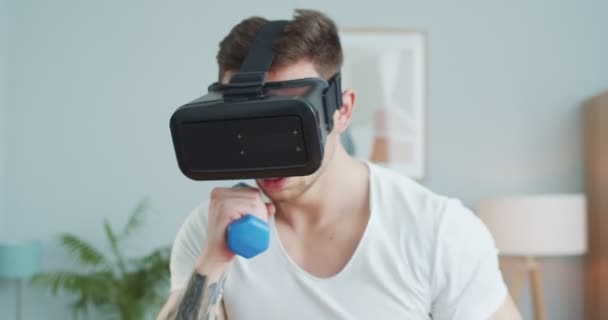 Primer plano caucásico atlético hombre entrenamiento en línea en gafas en casa. Joven boxeo masculino muscular, patadas, lucha con el oponente en la realidad virtual. Espacio VR, deportes digitales. Fitness, concepto de entrenamiento. — Vídeos de Stock