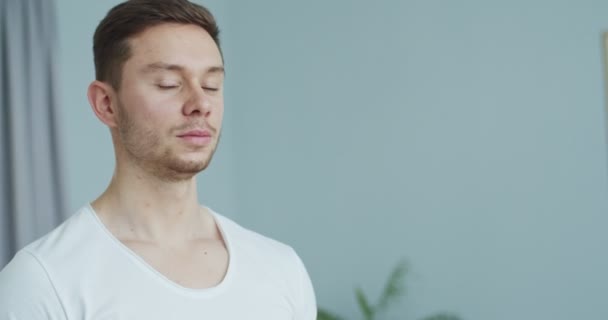 Portret van een aantrekkelijke jonge atletische man die thuis naar de camera kijkt. Close-up knappe blanke sportman die in de woonkamer staat. Fitness trainer poseren. — Stockvideo