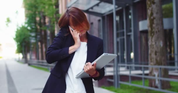 Een verwarde zakenvrouw met formele kleren, papieren en laptop. Goed uitziende blanke vrouwelijke kantoormedewerker die met collega 's praat en documenten controleert. Functie, beroepsbegrip. — Stockvideo