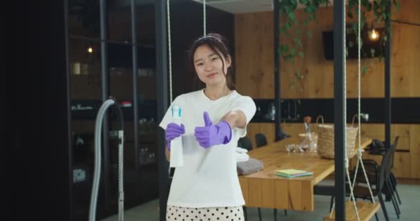 Zamknij się szczęśliwy wesoły młoda piękna azjatycka kobieta trzyma czystszy spray z rękami w rękawiczkach i patrząc w aparacie pokazującym kciuki do góry. Koncepcja sprzątania, sprzątania rodziny, stylu życia. — Wideo stockowe