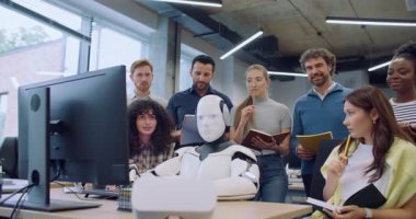 Çok ırklı meslektaşlar modern robotun etrafında toplanıyor. Cyborg elleri klavyede oturuyor ve başını sağa sola hareket ettiriyor. Takım şaşkın görünüyor. Olası sorunları düşünüyorum..