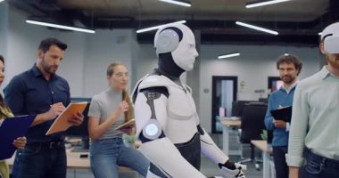 Birbirlerine yakın duran ve ofis binasındaki test sonuçlarını not eden çok ırklı bir grup mühendis. VR kulaklıklı bir adam insansı robotu çalıştırmaya çalışıyor. Cyborg erkekten sonra tekrarlıyor.