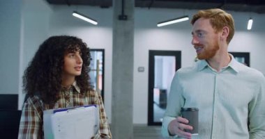 Beyaz adam ve kadın Long Office binasının ortasında adaya doğru yürüyorlar. Kıvırcık saçlı, evrak taşıyan bir kadın. Plastik bardaktan sıcak içecekten hoşlanan bir adam. Sohbet ederken.