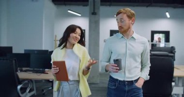 Çalışma alanlarında yürüyen sevimli bir çift. Sohbetin tadını çıkarırken öylesine konuşup gülümsüyor. Kahve molası sırasında akşam için olası planlardan bahsediyorduk. Modern oda. Monitörlü bir sürü masa.