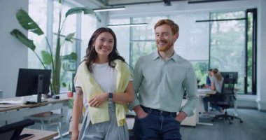 Mutlu insanlar yan yana dururken olumlu duygular ifade ediyorlar. Kameraya gülümseyen genç bir kadınla yakışıklı bir adam. Memnuniyet verici işçiler üretken çalışma günleriyle gurur duyarlar..