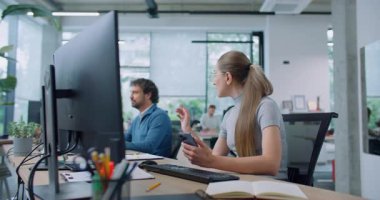 Çalışanların dikkati telefondan dağılıyor. Gözlüklü bir kadın sosyal ağlara takılıyor ve cep telefonunda video ya da fotoğraf gösteriyor. İnsanlar masalarında otururken neşeyle gülümsüyor..