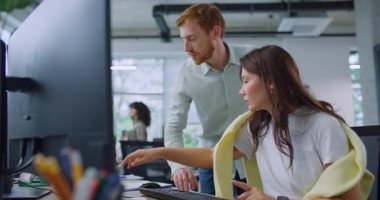 Bilgisayarda önemli bilgileri analiz eden ya da karşılaştıran profesyonel melez yöneticiler. Kadının yanında duran ve işini bitirmesine yardım eden yakışıklı bir adam. İşbirliği kavramı.