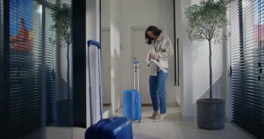 Beyaz kadın ceketine kemer bağlıyor. Cep telefonuyla konuşuyorum. Uzaktan iletişim için akıllı telefonu kullanmak. Yolculuk için bir bavul alıyorum. Bagajı bırakmak ya da unutmak. Uçuşa geç kaldım..