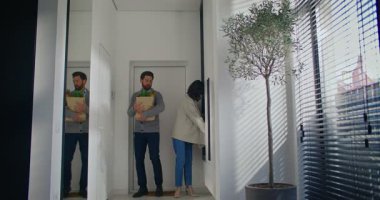 Beyaz bir çift daireye giriyor. Kadın büyük aynada bakışlarını kontrol ederken antrede durmak. Birbirleriyle konuşup iltifat ediyorlar. Elinde yeni ürünlerle dolu bir çanta tutan adam..