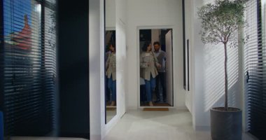 Kafkasyalı mutlu çift daireye giriyor. İnsanlar tatillerinden döndüler. Sevdiğinle başarılı bir yolculuk. Eve giriyorum. Tekerlekli bavul taşıyorum. Kucaklaşan sevgili ya da eş.