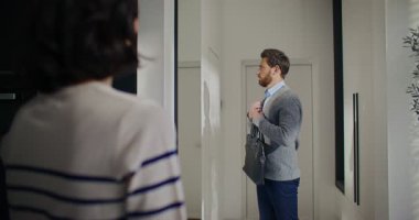 Kadın omzunun arkasından bak. Karı kocaya bakıyor, işe hazırlanıyor. Adam büyük aynanın önünde kıyafetlerini kontrol ediyor. Sevilen kadına el sallarken evrak çantasını tutmak. Veda ediyorum.