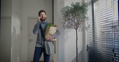 Kamera, sakallı, beyaz bir adamın etrafında hareket ediyor. Market poşeti taşıyan bir erkek. Akrabası ya da kız arkadaşı ile telefonda konuşuyor. Komik bir şey duyduktan sonra gülümsüyor ve gülüyor. Pencerenin dışına bak.