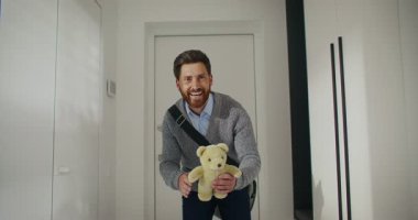 Arkasından kapıyı kapatan beyaz sakallı bir adam. Erkek, evine oyuncakla giriyor. Sarışın, sevgili kızı için. Zor bir iş gününden sonra eve gelmek. Aileye sevgi göstermek.