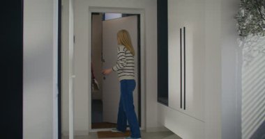 Güzel beyaz kadın dairesinde kuryeye kapıyı açıyor. Teslimatçı bir eliyle telefonu tutarken diğer eliyle kağıt paketi taşıyor. Sıralama bilgilerini kontrol eden ve kutucuğu istemciye veren adam.