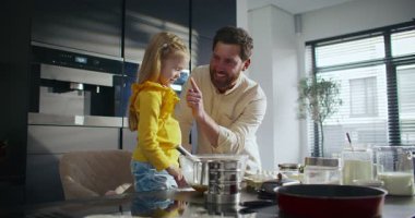 Kafkasyalı güzel bir aileye yakınlaşmak yemek hazırlarken eğlenmek. Küçük kızının burnunu tek parmakla dürten mutlu bir baba. Yüzünde un izi bırakıyor. Birbirleriyle komik etkileşimler..