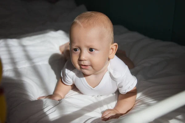 Toddler 6 months lies on his tummy and shows emotions — Stock Photo, Image
