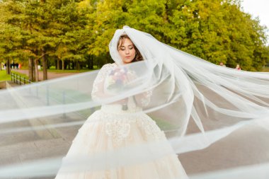 Rüzgarda gelişen peçeli bir gelin portresi.