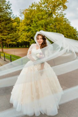 Rüzgarda gelişen peçeli bir gelin portresi.
