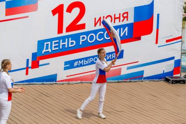Rusya, Vladivostok, 06/12/2018. Childs'ın renkli Garnit¸rleri Rus bayrağı olarak boyalı olarak sahnede şarkı gerçekleştirin. Haziran 12 yıllık Rusya günü kutlaması. Çocukların performans. Tatil gösteri ve Etkinlikler.