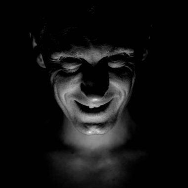 Stylish portrait of adult caucasian man. He smiles like maniac and seems like maniac or crazy. Black and white shot, low-key lighting. clipart