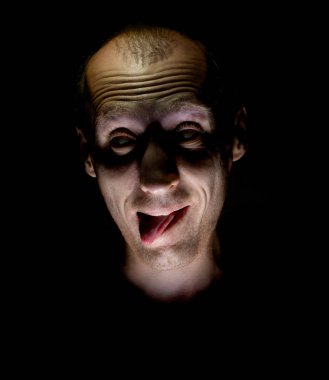 Deli gibi gülümsüyor ve onun dilini sopa yetişkin beyaz adam şık karanlık mizahi portresi.