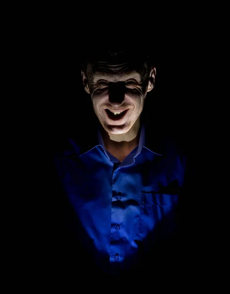 Stylish dark portrait of adult caucasian man who seems like maniac or psycho. Isolated on black background. Low-key lighting.