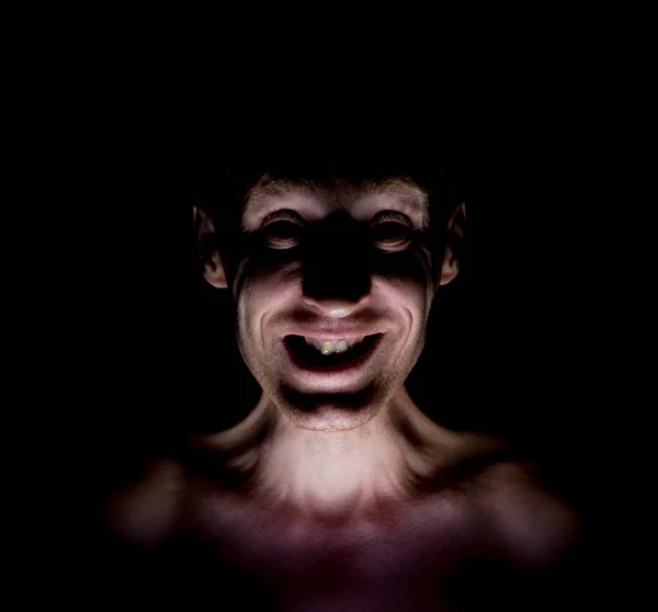 Stylish dark portrait of caucasian man who smiles like a mad or maniac.