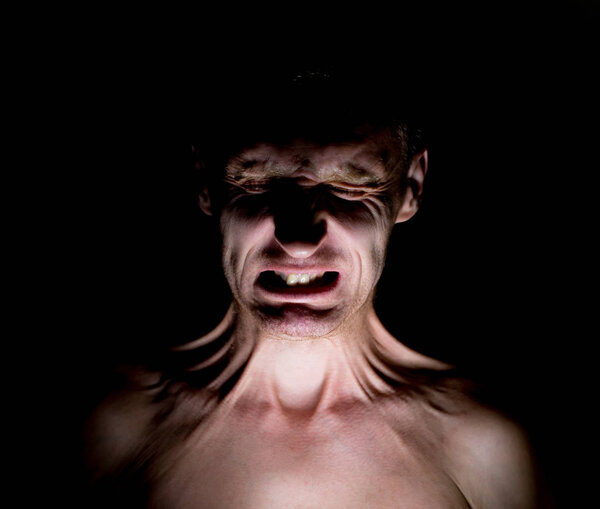 Stylish dark humorous portrait of adult caucasian man who funny wrinkles his face.