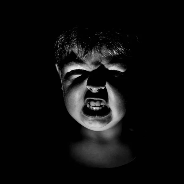 Öfke Genç beyaz çocuk portresi. Korku ve saldırganlık kavramı. Siyah ve beyaz vurdu, düşük anahtar aydınlatma. Siyah izole.