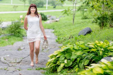 Yaz parkında güzel beyaz elbiseli sevimli genç beyaz kadın portresi.