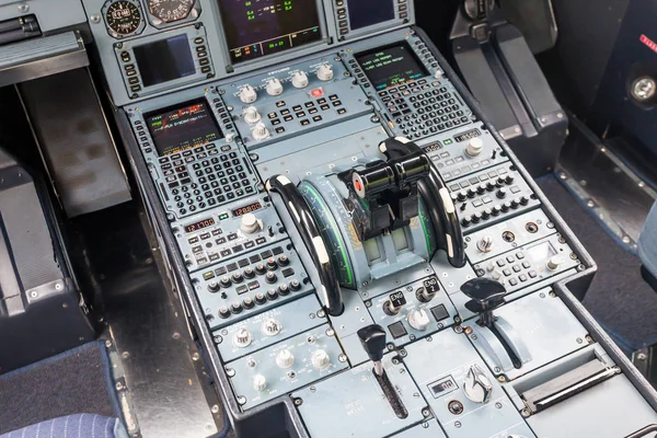 Interior view of pilot cabine in actual modern passenger jet airplane. Many buttons, navigation devices on dashboard. Aviation and transportation.