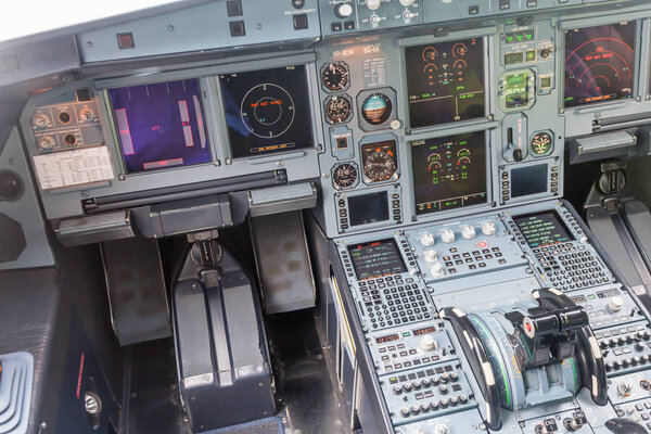 Interior view of pilot cabine in actual modern passenger jet airplane. Many buttons, navigation devices on dashboard. Aviation and transportation.