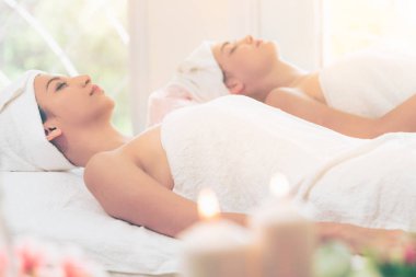Spa yatağında uzanan rahat genç bir kadın lüks bir spa merkezinde yüz bakımı ve masaj için hazırlandı. Sağlık, stres atma ve gençleştirme kavramı.