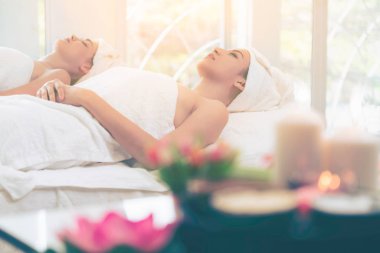 Spa yatağında uzanan rahat genç bir kadın lüks bir spa merkezinde yüz bakımı ve masaj için hazırlandı. Sağlık, stres atma ve gençleştirme kavramı.