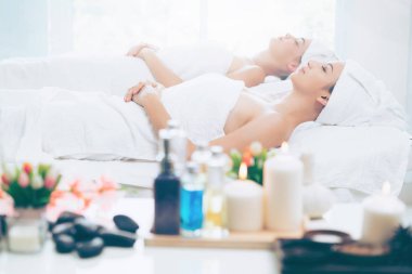 Spa yatağında uzanan rahat genç bir kadın lüks bir spa merkezinde yüz bakımı ve masaj için hazırlandı. Sağlık, stres atma ve gençleştirme kavramı.