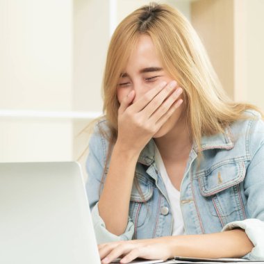 Genç kadın ofiste bilgisayar kullanırken güler. Küçük işletme kavramı.