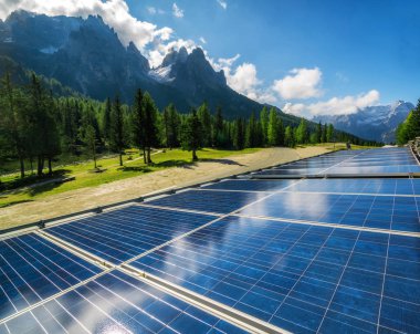 Solar cell panel in country landscape against sunny sky and mountain backgrounds. Solar power is the innovation for sustainability of world energy. Sustainable resources. clipart
