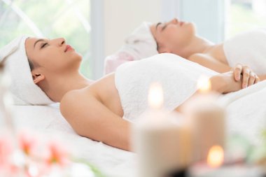 Spa yatağında uzanan rahat genç bir kadın lüks bir spa merkezinde yüz bakımı ve masaj için hazırlandı. Sağlık, stres atma ve gençleştirme kavramı.